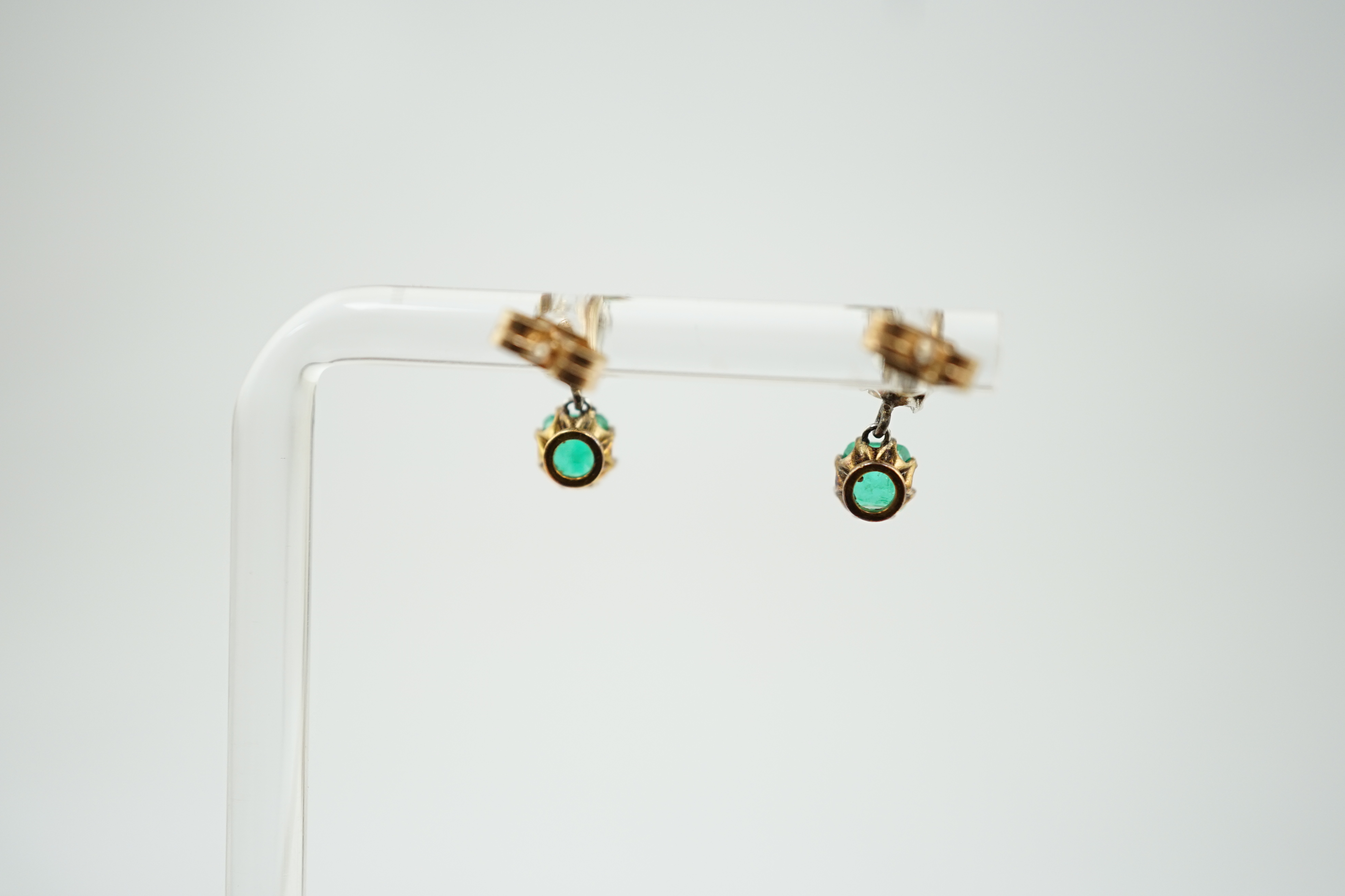 A pair of late 19th/early 20th century gold and platinum, emerald and diamond set two stone drop earrings